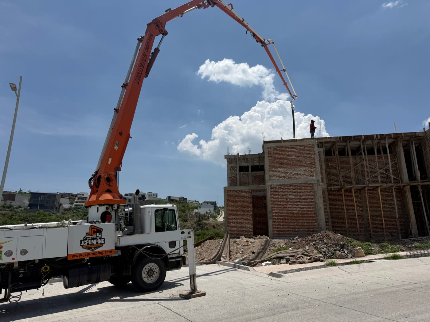 Pluma de JC Pumping colando el techo de una construcción de tabique